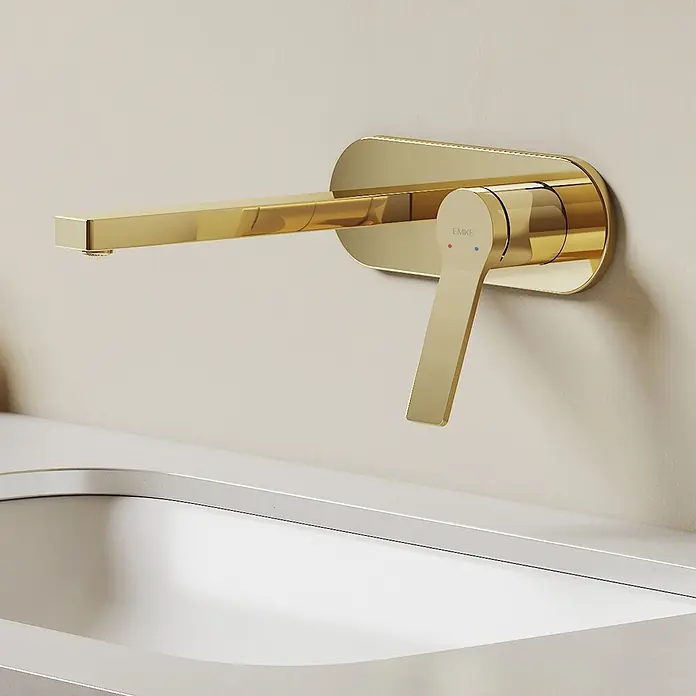 Emke Waschtischarmatur Arcspout XF22 - Gold, Glänzend - Wandmontierte goldene Armatur mit einem Einhebelmischer, mit roten und blauen Temperaturanzeigen, über einem weißen Waschbecken.
