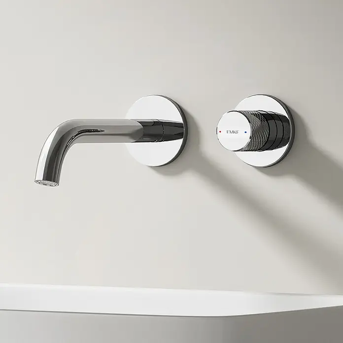 Emke Waschtischarmatur Griprill XF22 - Chrom, Glänzend - Wandmontierte Armatur aus poliertem Chrom mit separatem strukturiertem Griff, Heiß- und Kaltwasseranzeige, über einem weißen Waschbecken.