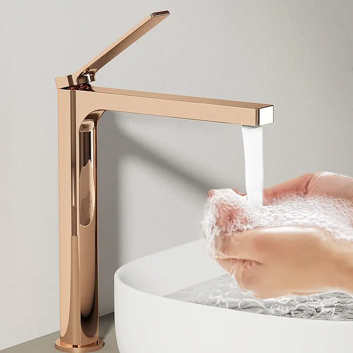 Emke Waschtischarmatur Arcspout XF21 - Roségold, Glänzend - Roségoldene Armatur mit texturierter Oberfläche, die Wasser in Hände spendet, die in einem weißen Becken waschen.