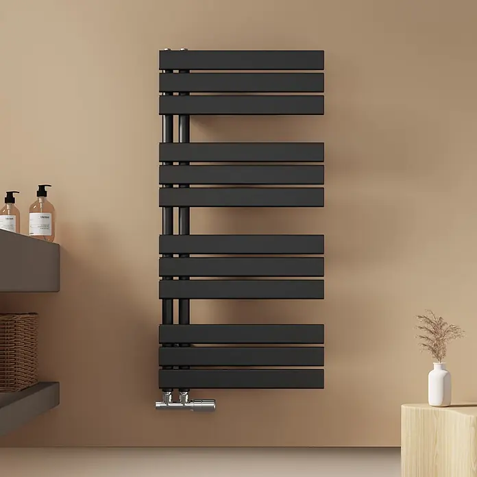 Emke Badheizkörper Flatrad SFTR1 - Schwarz - Schwarzer Handtuchheizkörper an beiger Wand in einem modernen Badezimmer.
