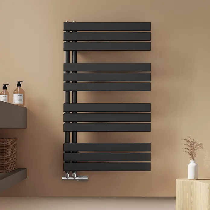 Emke Badheizkörper Flatrad SFTR1 - Schwarz - Schwarzer Handtuchheizkörper aus Metall an einer beigen Wand in einem Badezimmer.