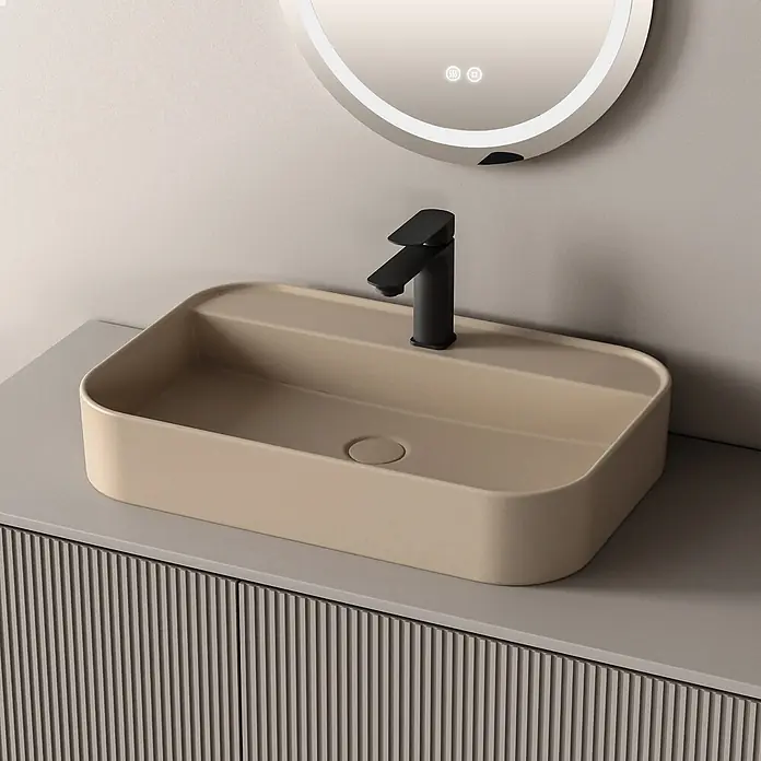Emke Aufsatzwaschbecken Ceraform CB02 - Hahnloch: Mitte, Ohne Überlauf, Beige - Beiges, rechteckiges Waschbecken mit schwarzem Wasserhahn auf grauem Unterschrank, unter beleuchtetem Spiegel.