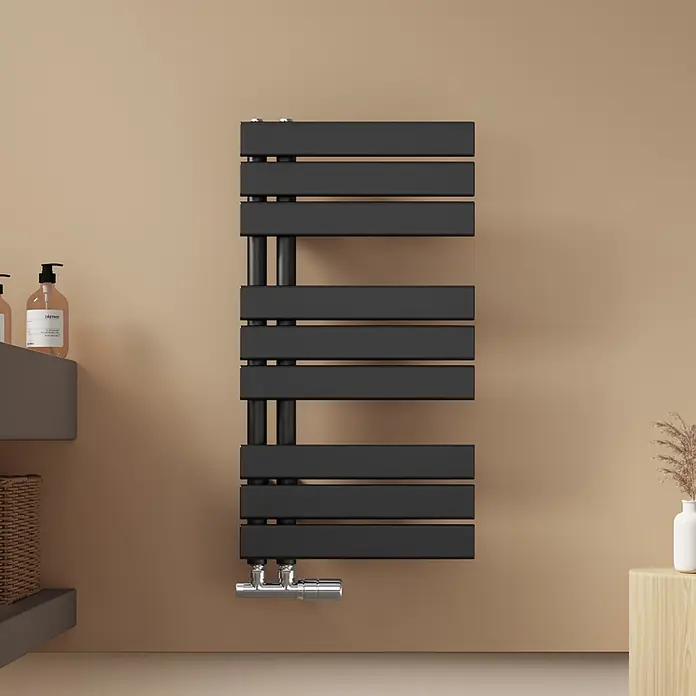 Emke Badheizkörper Flatrad SFTR1 - Schwarz - Schwarzer, rechteckiger Handtuchheizkörper mit Chromarmaturen an beiger Wand im modernen Badezimmer.