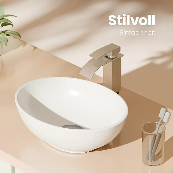 Emke Aufsatzwaschbecken Bovelari CB05 - Hahnloch: Ohne, Ohne Überlauf, Weiß - Weißes, ovales Aufsatzwaschbecken mit gebürstetem Wasserhahn auf beigefarbenem Waschtisch, daneben Zahnbürsten und Pflanze.