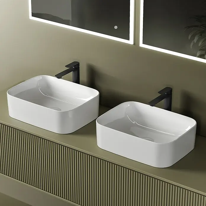 Emke Aufsatzwaschbecken Ceraform CB09 - 38 x 61 cm, Hahnloch: Ohne, Ohne Überlauf, Weiß - Zwei weiße rechteckige Aufsatzwaschbecken mit schwarzen Armaturen auf einem geriffelten grünen Waschtisch, unter hinterleuchteten Spiegeln.