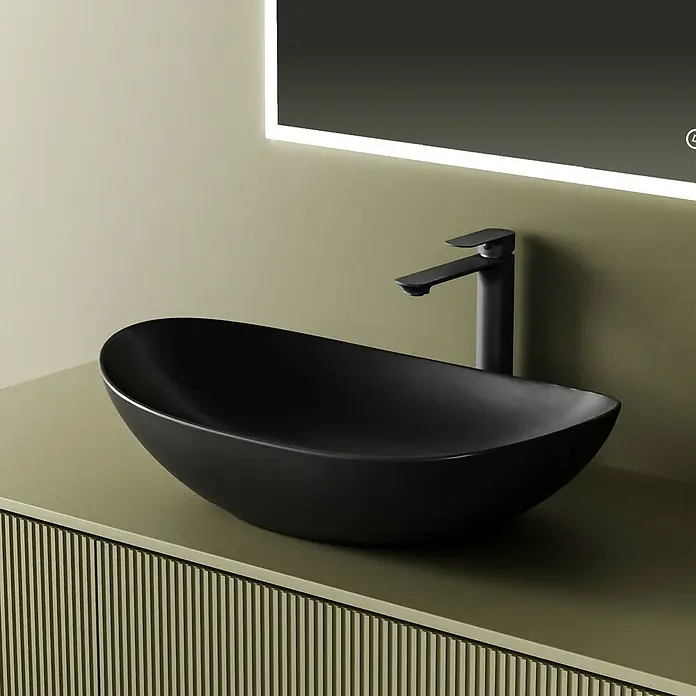 Emke Aufsatzwaschbecken Bovelari CB05 - 36 x 61,5 cm, Hahnloch: Ohne, Ohne Überlauf, Schwarz - Mattschwarzes Aufsatzwaschbecken mit passendem Wasserhahn auf geriffelter grüner Waschtischplatte unter beleuchtetem Spiegel.