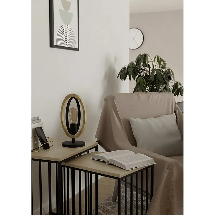 Eglo Basildon Tischleuchte - 40 W, L x B x H: 19 x 16 x 34,5 cm, E27 - Zwei Beistelltische mit hellen Holzplatten und schwarzen Metallgestellen, als Ablage neben einem Sessel mit Lampe, Telefon und Buch.