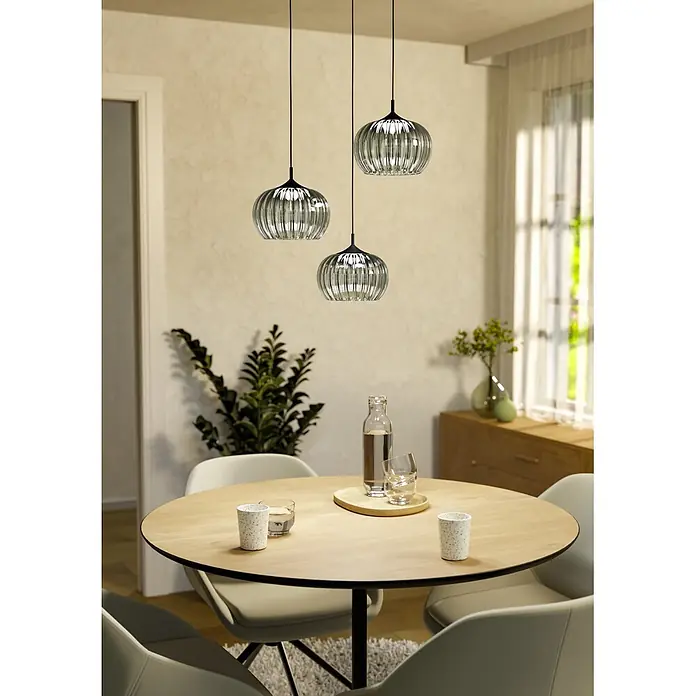 Eglo LED-Pendelleuchte rund - Ø x H: 42,5 x 110 cm, Grün, Schwarz, Warmweiß - Drei Pendelleuchten mit geriffelten Klarglasschirmen und schwarzer Aufhängung über einem Holzesstisch.