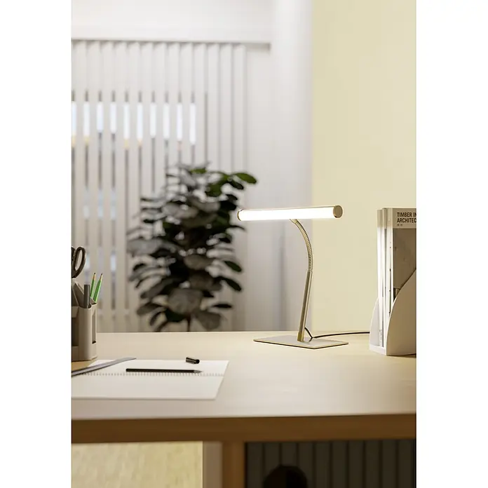 Eglo LED-Tischleuchte Riccione - 5 W, L x B x H: 30 x 19 x 39,5 cm, Nickel, Warmweiß - Messingfarbene Schreibtischlampe mit flexiblem Arm und linearer LED-Lichtleiste auf einem Holzschreibtisch.