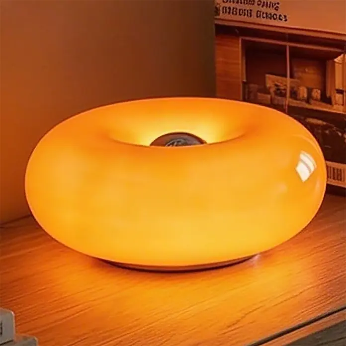 Eglo LED-Tischleuchte rund Basile - 8 W, Ø x H: 30 x 12 cm, Orange, Warmweiß - Leuchtende orangefarbene Donut-Tischlampe auf einer Holzoberfläche.