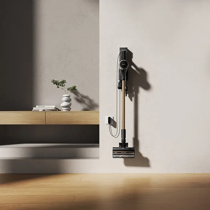 Mova Aspirador de batería S5 Sense - 570 W, Volumen de recipiente: 0,6 l - Aspiradora escoba negra y dorada montada en pared clara, cargándose, junto a una consola de madera.