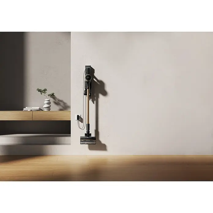 Mova Aspirador de batería S5 Sense - 570 W, Volumen de recipiente: 0,6 l - Aspiradora escoba sin cable negra y dorada, montada en la pared y cargando.