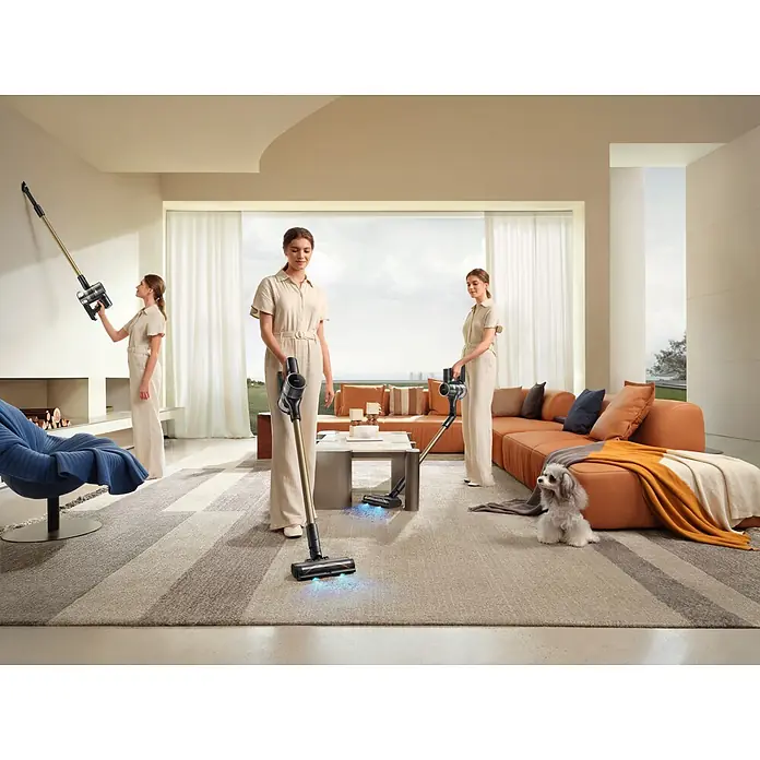 Mova Aspirador de batería S5 Sense - 570 W, Volumen de recipiente: 0,6 l - Aspiradora sin cable dorada y negra utilizada por una mujer en un salón moderno, limpiando suelos y superficies altas.