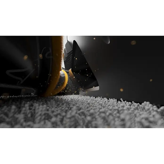 Mova Aspirador de batería S5 Sense - 570 W, Volumen de recipiente: 0,6 l - Primer plano de un cabezal de aspiradora con cepillo giratorio naranja limpiando residuos granulares blancos, con partículas volando.