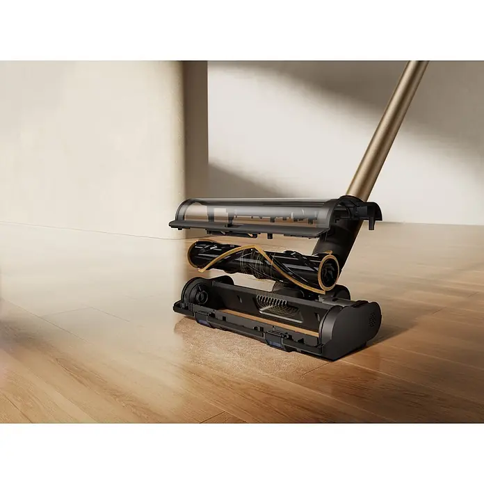 Mova Aspirador de batería S5 Sense - 570 W, Volumen de recipiente: 0,6 l - Vista en sección de un cabezal de aspiradora negro y dorado sobre suelo de madera, mostrando su rodillo interno a punto de recoger polvo.