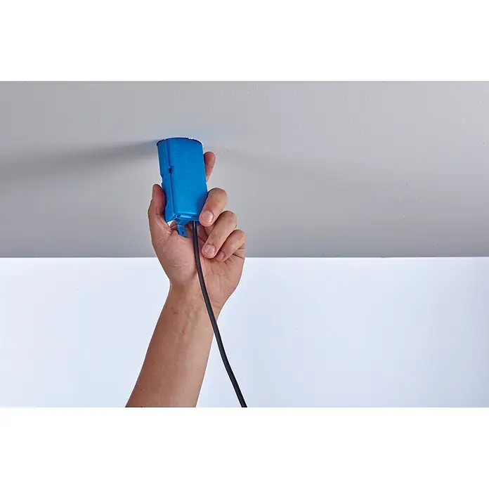 Ideal Kabelbox In-Sure Box 30-4000-1 - 1 Stk. - Hand führt blaue Kunststoff-Elektrodose mit schwarzem Kabel in Deckenöffnung ein.