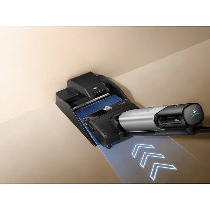 Mova Aspirador en seco y húmedo de batería X4 Pro - 450 W, Volumen de recipiente: 760 ml - Robot limpiador de suelos negro y plata acoplado en su estación sobre suelo beige, flechas azules indican limpieza.