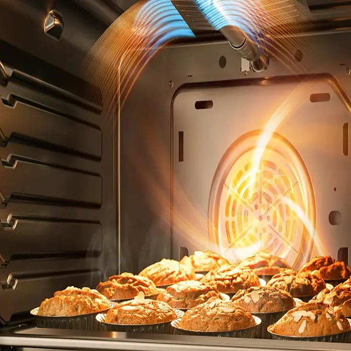 Midea Horno empotrado MBOG2-D2M90 - Volumen horno: 70 l, Número de tipos de calentamiento: 9 ud. - Interior de un horno con muffins dorados horneándose en una rejilla. Ventilador de convección y resistencias brillan, circulando el calor.