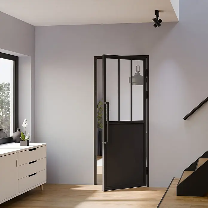 Inova Zimmertür Lofttür Komplettset Stahl DIN Rechts - 930 x 2.040 mm, DIN Anschlag: Rechts, Schwarz - Schwarze Innentür mit Glas- und Massivfeldern, teilweise geöffnet in einem modernen Flur.