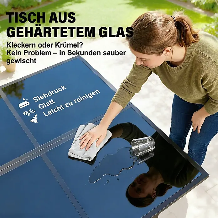 Outsunny Gartentisch-Set - Gesamtumfang: 5 -tlg., Stahl, Gehärtetes Glas, Netzstoff, Baumwoll, Klappbar - Eine Frau wischt eine verschüttete Flüssigkeit von einem schwarzen Outdoor-Tisch aus gehärtetem Glas. Seine glatte, leicht zu reinigende Oberfläche wird hervorgehoben.