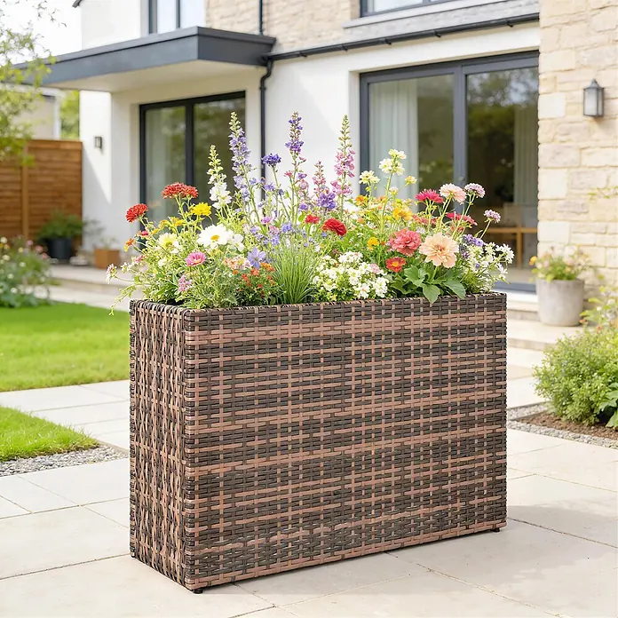 Outsunny Pflanzkasten - 1 Stk., Stahl, Braun - Rechteckiger Pflanzkübel aus braunem und dunkelbraunem Rattan mit bunten Blumen auf einer Terrasse.