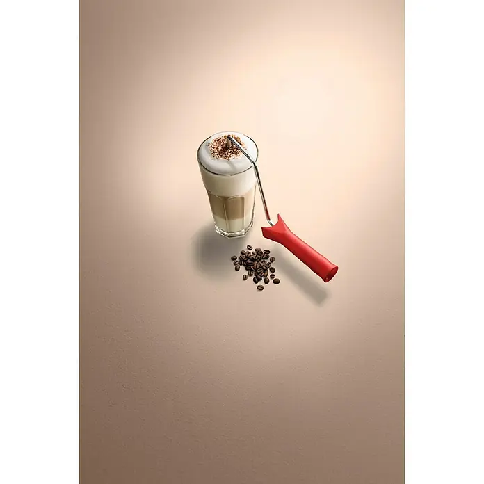 SCHÖNER WOHNEN-Farbe Wandfarbe Trendfarbe - Macchiato, Matt, 1 l, Konservierungsmittelfrei - Ein Glas Latte Macchiato mit Kaffeebohnen und einem roten Farbroller auf beigem Untergrund.