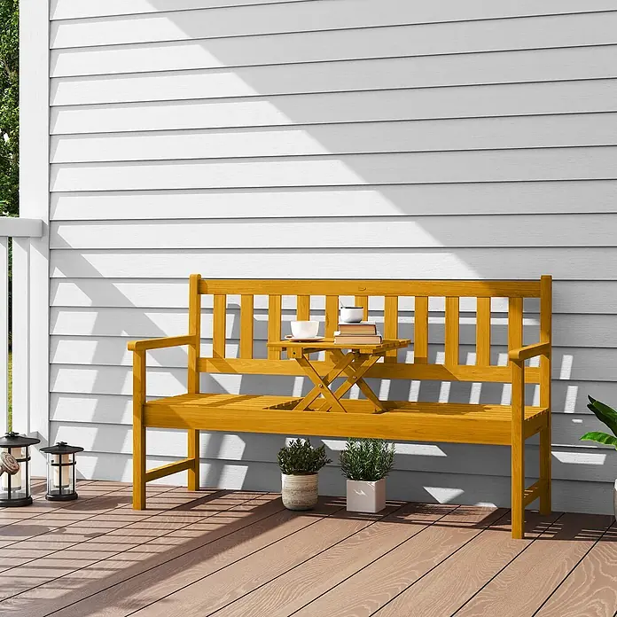 Outsunny Gartenbank - B x T x H: 56,5 x 57 x 89 cm, Akazienholz, Teak - Gelbe Holz-Gartenbank mit Beistelltisch und Büchern/Tassen auf einer Veranda.