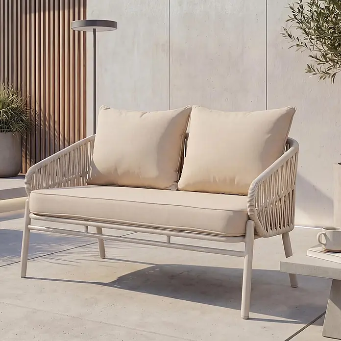 Proregal Loungesofa - Aluminium, Beige - Helles beiges Outdoor-Zweisitzer-Sofa mit geflochtenen Seilseiten und dicken Kissen auf einer modernen Terrasse.