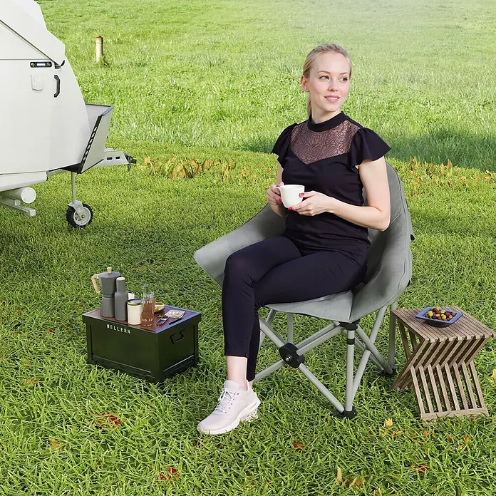 Outsunny Campingstuhl - Kunstleder, Metall, Klappbar, Dunkelgrau, B x T x H: 63 x 63 x 100 cm - Klappbarer grauer Campingstuhl mit einer Frau, die draußen entspannt und eine Tasse hält.
