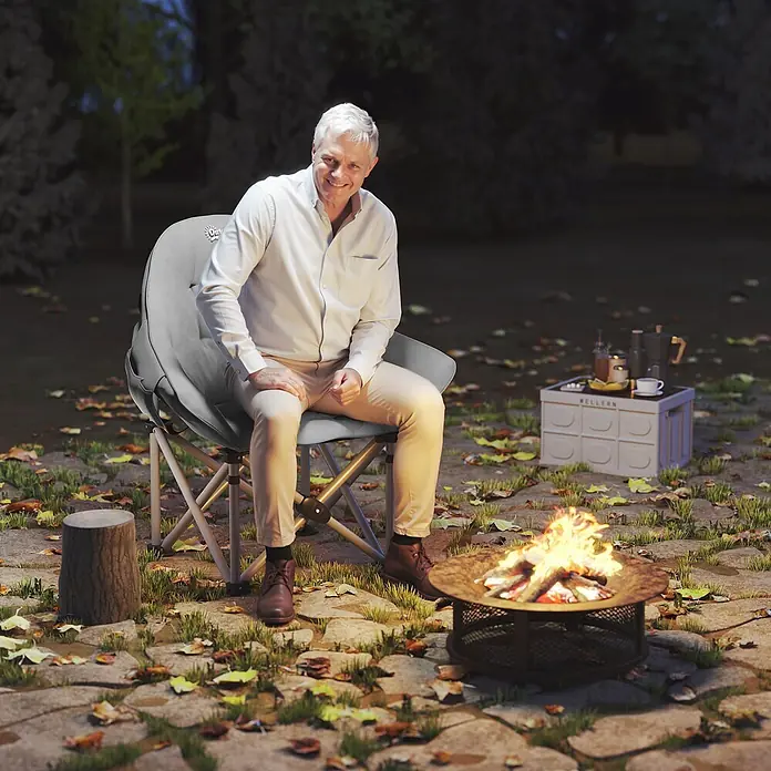Outsunny Campingstuhl - Kunstleder, Metall, Klappbar, Dunkelgrau, B x T x H: 63 x 63 x 100 cm - Mann sitzt bequem in einem grauen, klappbaren Outdoor-Stuhl am Lagerfeuer, mit einem tragbaren WELLERN Tisch in der Nähe, ideal zur Entspannung.