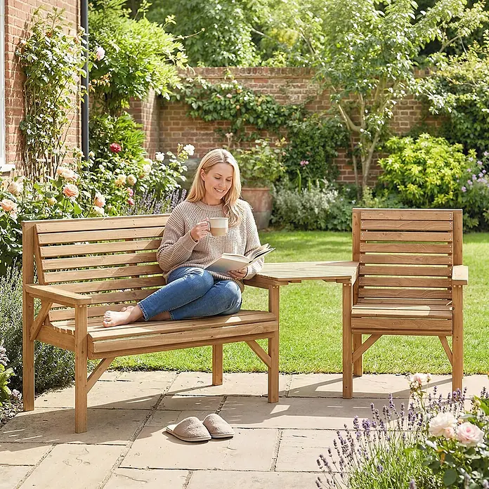 Outsunny Gartenbank Naturholz, 121cm x 65cm x 90cm - Tannenholz, Naturholz - Gartenbank aus Holz mit integriertem Tisch und Stuhl. Eine Frau entspannt lesend und trinkend darauf.