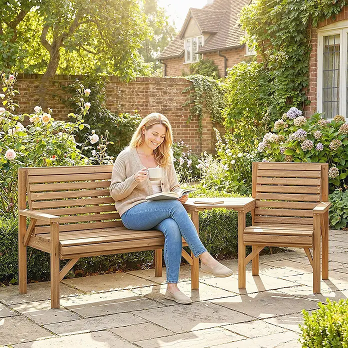 Outsunny Gartenbank Naturholz, 121cm x 65cm x 90cm - Tannenholz, Naturholz - Eine Frau entspannt auf einer Gartenbank aus Naturholz mit Buch und Tasse, neben passendem Stuhl und kleinem Tisch im Garten.