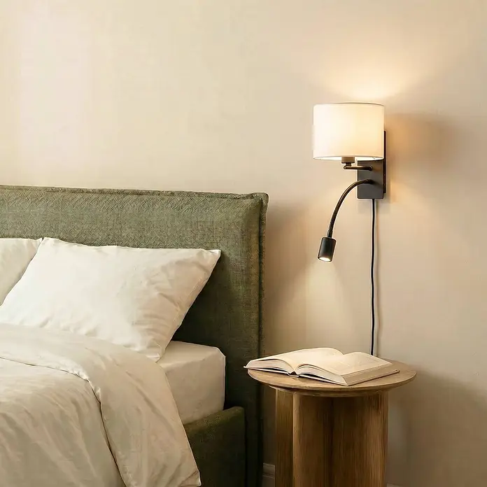 Lindby Wandleuchte Florens - weiß / opal, E14 - Wandleuchte mit weißem Stoffschirm und flexibler schwarzer LED-Leselampe, neben einem Bett zur Lektüre installiert.