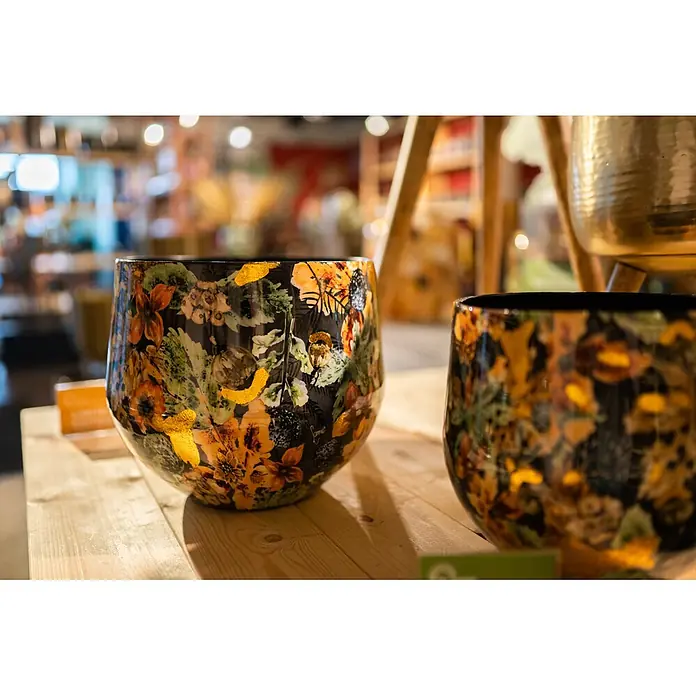 Ter Steege Übertopf rund Berry - Ø x H: 21 x 16 cm, Metall, Blau/Orange - Zwei dekorative Pflanzgefäße mit lebhaften Blumenmustern in Orange, Grün und Gold auf dunklem Grund, auf einem Holztisch präsentiert.