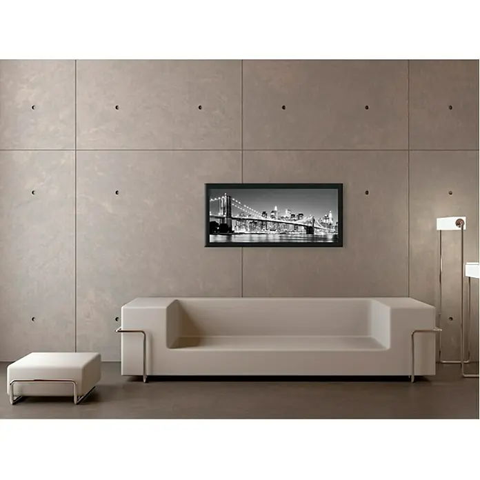 ProArt Bild Oversized - Night-Bridge, B x H: 124 x 50 cm - Elegantes Wohnzimmer mit einem modernen Sofa, einem stilvollen Hocker und einem gerahmten Bild von einer Brücke. Die Einrichtung strahlt Minimalismus aus.