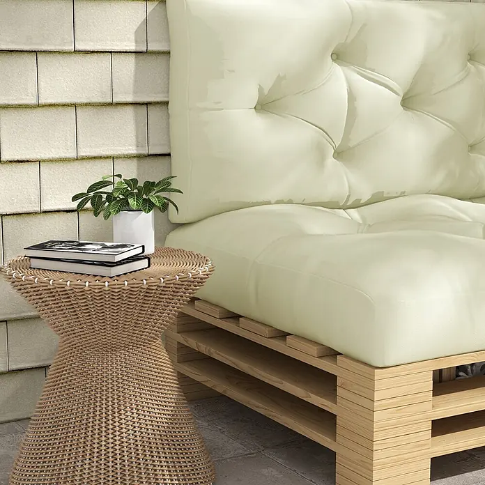 Outsunny Bankauflage Palettensitzpolster - Dekopaletten, 1 Stk., 100% Polyester, Cremeweiß - Outdoor-Sofa mit hellcremefarbenen getufteten Kissen auf Holzpaletten, daneben ein geflochtener Beistelltisch mit Büchern und Pflanze.