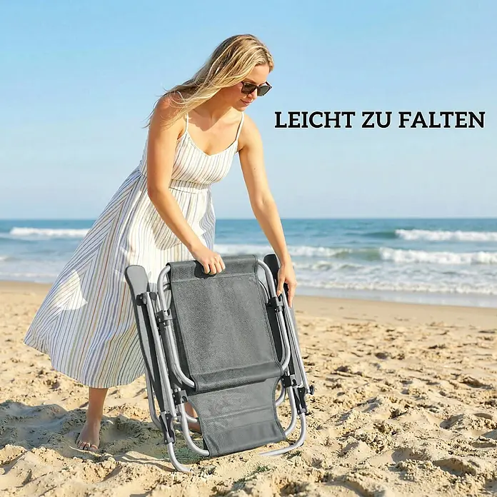 Outsunny Campingstuhl - Aluminium, Atmungsaktives Netz, Klappbar, Dunkelgrau, B x T x H: 62 x 68 x 79 cm - Grauer klappbarer Strandstuhl wird von einer Frau am Sandstrand zusammengefaltet, was seine einfache Faltbarkeit hervorhebt.