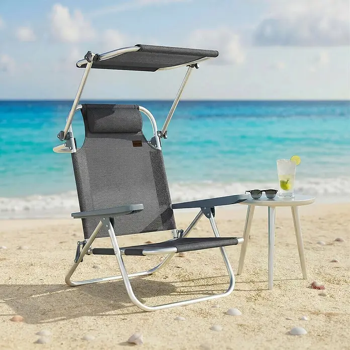 Outsunny Campingstuhl - Aluminium, Atmungsaktives Netz, Klappbar, Dunkelgrau, B x T x H: 62 x 68 x 79 cm - Dunkelgrauer Strandstuhl mit Sonnenverdeck und Metallgestell am Sandstrand. Ein Beistelltisch mit Getränk und Sonnenbrille steht daneben.