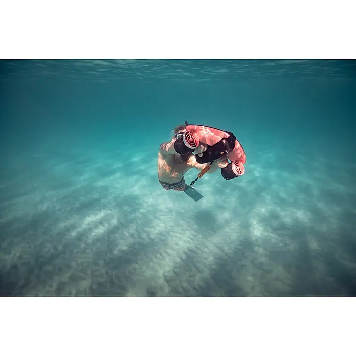 Sublue Tauchscooter Navbow 2026 - L x B x H: 486 x 327 x 177 mm - Eine Person nutzt einen rot-schwarzen Unterwasser-Scooter im klaren blauen Wasser.