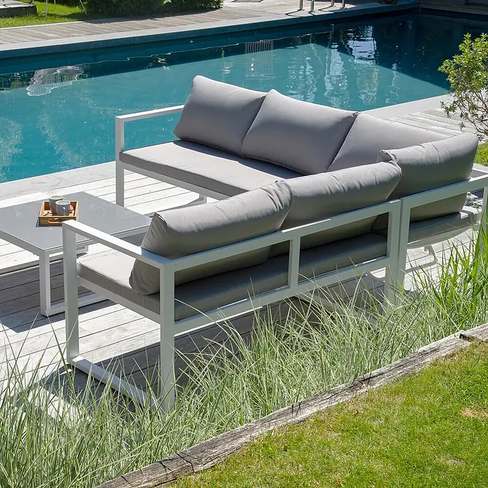 Happy Garden Loungemöbel-Set IBIZA - 2 -tlg., Aluminium, Grau - Weißes Garten-Ecksofa mit grauen Kissen und passendem Couchtisch am Pool.