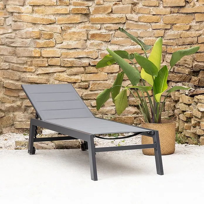 Happy Garden Gartenliege BARBADOS - Grau, Aluminium, Rückenlehne verstellbar - Dunkelgraue Outdoor-Liege mit Rollen auf einer Terrasse neben einer Pflanze. Ideal zur Entspannung im Garten oder am Pool.