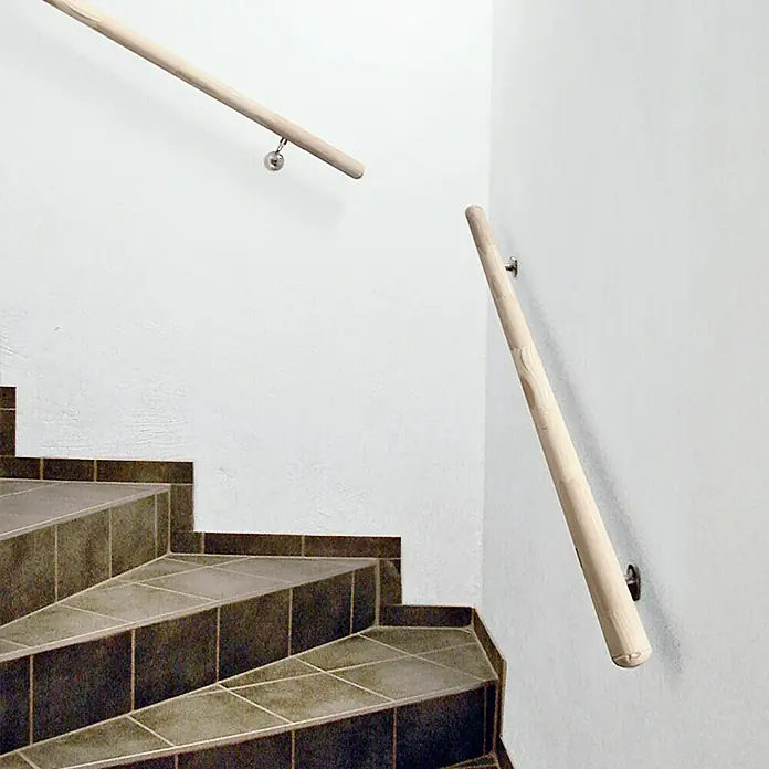 Treba Frewa Handlauf-Set H19 - Fichte, Unbehandelt, Länge: 1.500 mm - Eine Nahaufnahme einer hölzernen Treppe mit Handläufen an einer weißen Wand, die die sauberen Linien und die minimalistische Ästhetik hervorhebt.