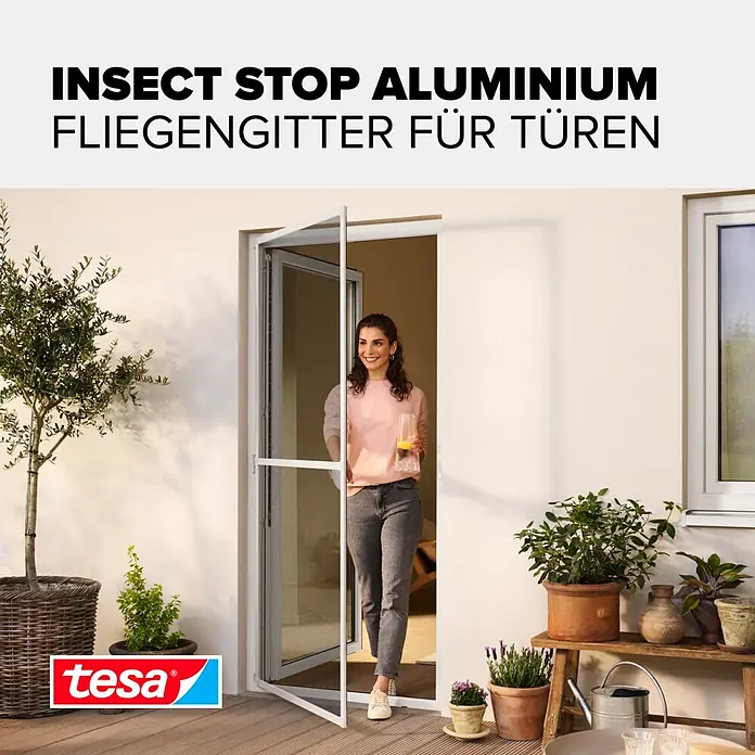 Tesa Insect Stop Insektenschutztür - B x H: 1 x 2,2 m, Montage Insektengitter: Schrauben - Weißes Aluminium-Fliegengitter für Türen, von einer Frau auf einer Terrasse geöffnet.