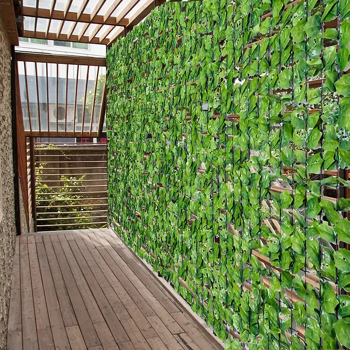 Outsunny Sichtschutzelement - Kunststoff, Hellgrün - Künstlicher grüner Blätter-Sichtschutz an einer Wand auf einem Holzbalkon, bietet Grün und Abgeschiedenheit.