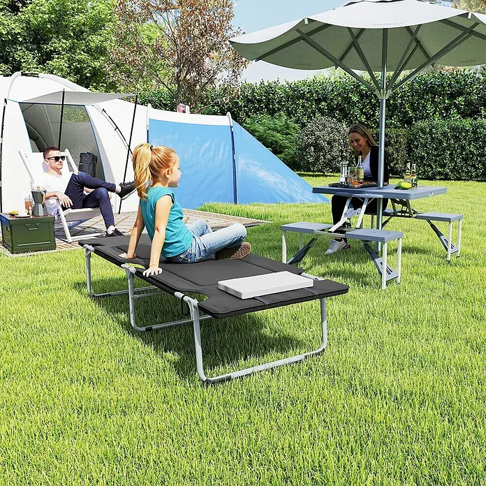 Outsunny Campingliege - Schwarz, Silber, B x T: 66 x 183 cm, Stahl, Klappbar - Graues Klappbett und Picknicktisch mit Bänken, von Personen im Freien genutzt.