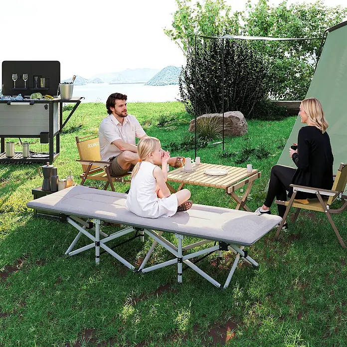 Outsunny Campingliege - Grau, B x T: 65 x 185 cm, Stahl, Klappbar - Hellgraues Campingbett mit silbernem Gestell, von einem Kind auf einem Campingplatz am See genutzt.