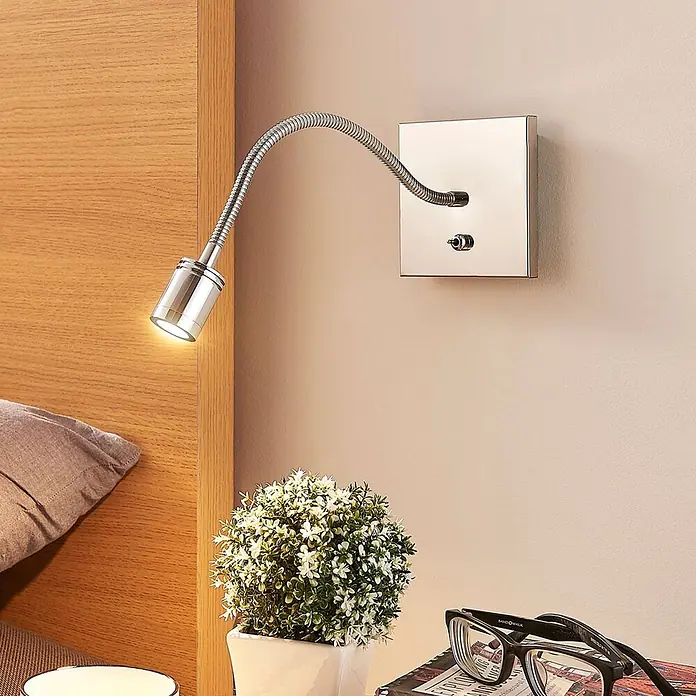 Lindby Wandleuchte Berfin - chrom / silber, chrom / silber - Chrom-Wandleseleuchte mit flexiblem Schwanenhals, neben einem Bett für fokussiertes Licht montiert.