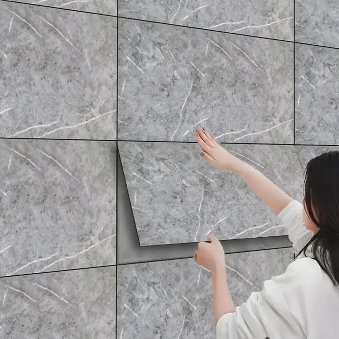 Panel de pared Piedra - 60 x 30 cm, Gris, 2 ud. - Azulejos de pared autoadhesivos con diseño de mármol gris siendo aplicados en una pared.