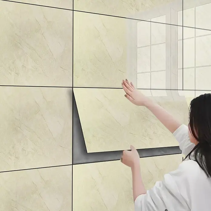 Panel de pared Travertino - 60 x 30 cm, Beige, 2 ud. - Azulejo de pared autoadhesivo de mármol beige claro siendo aplicado, mostrando su parte trasera despegable.