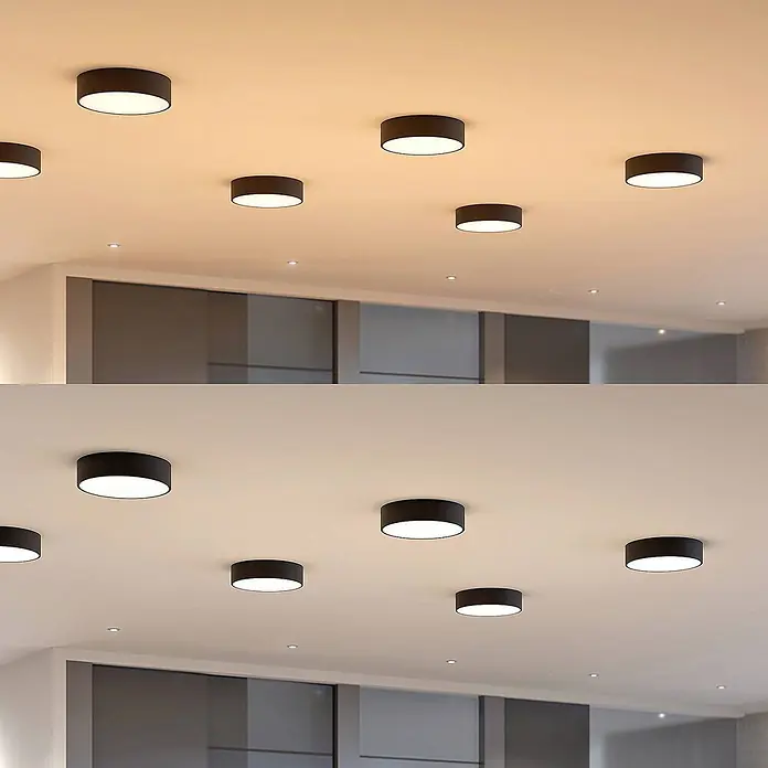 Arcchio Deckenleuchte Noabelle - schwarz, schwarz - Dunkle zylindrische Deckenleuchten in einem modernen Raum, die warme und kühle Lichtfarben zeigen.